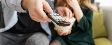 A woman and man holding a TV remote.